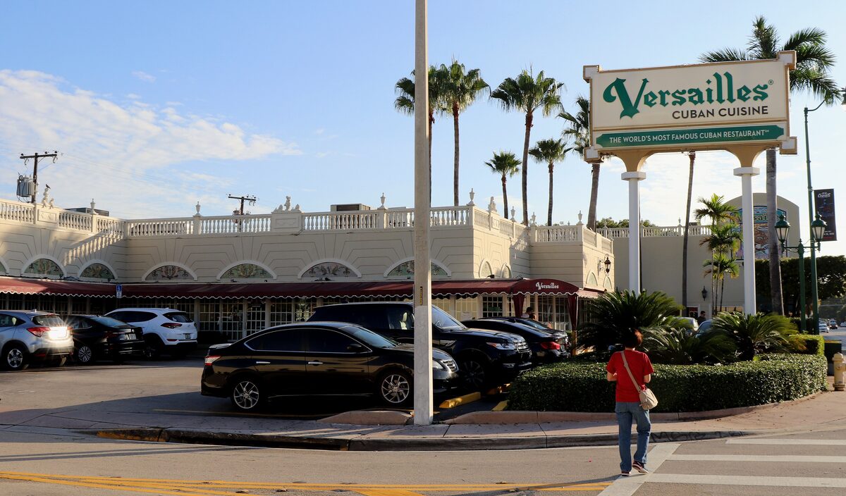 The Versailles restaurant on Calle Ocho, a cream building with a green sign and palms in front
