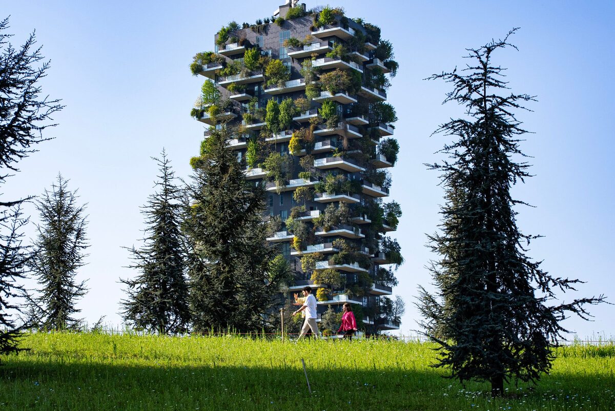 A Bosco Verticale tower covered in trees, seen from the park