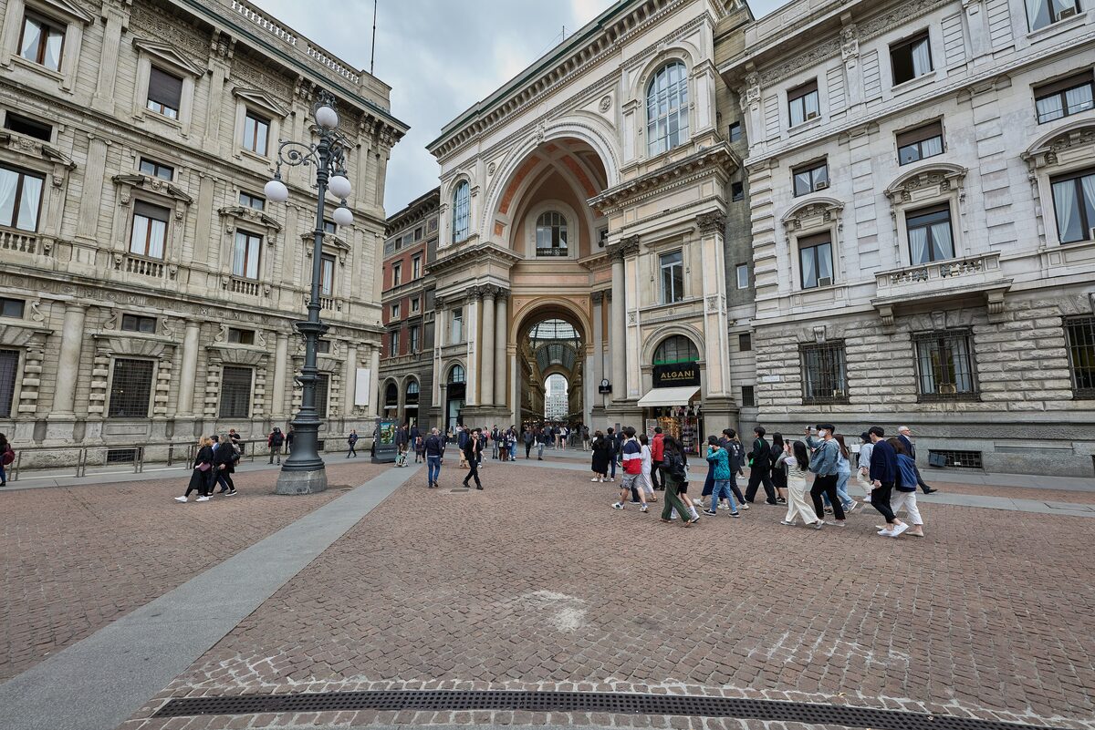 The arched entrance to the Galleria, with people crossing the square