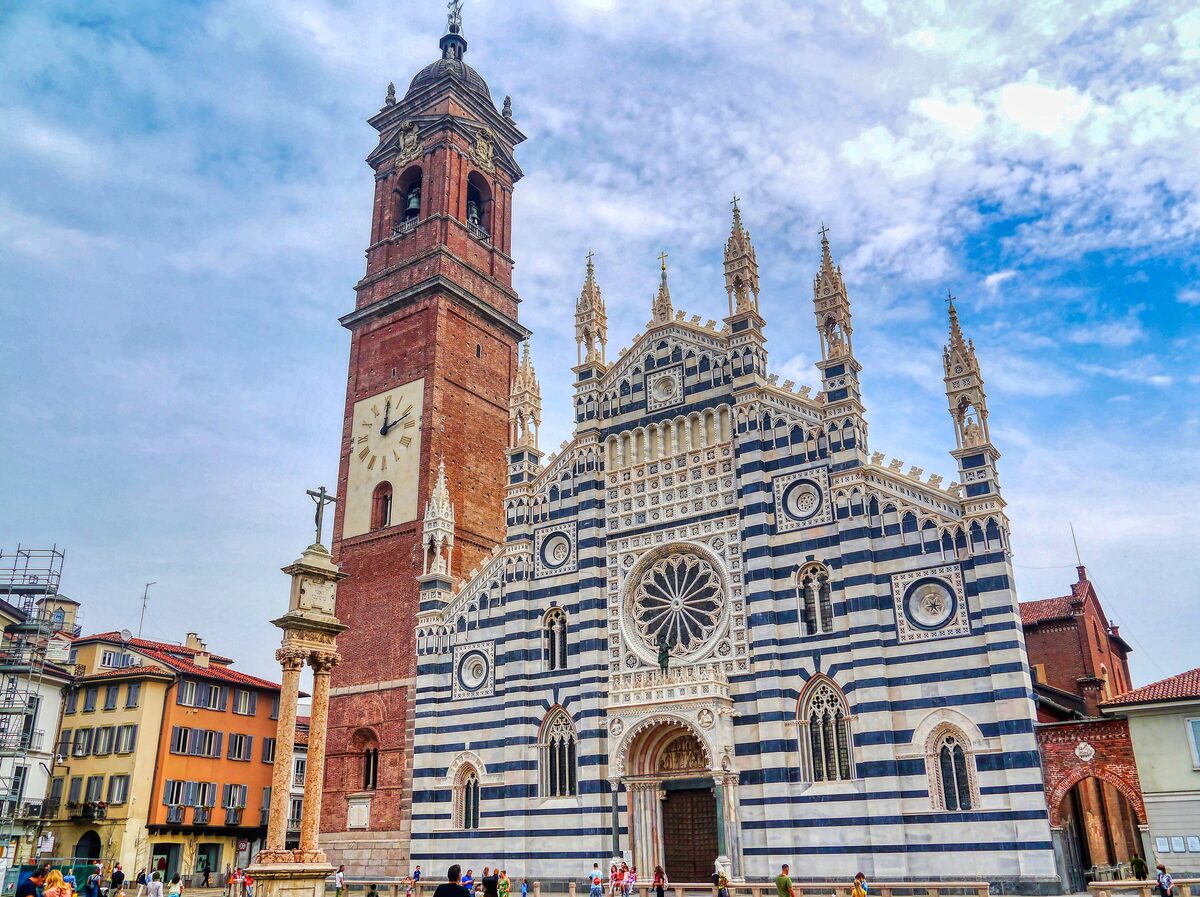 The striped marble facade and brick bell tower of Monza Cathedral