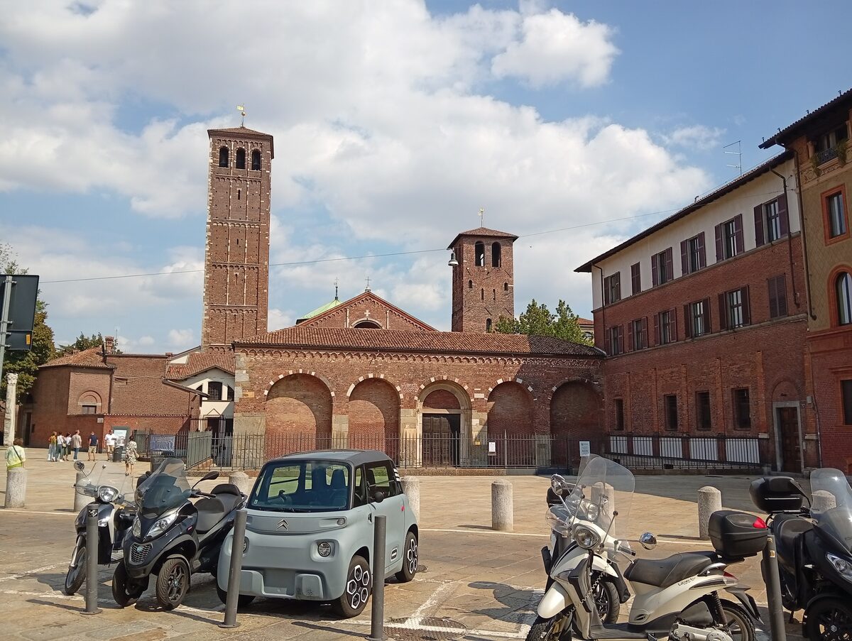 Brick towers and arcaded facade of Sant'Ambrogio on its square