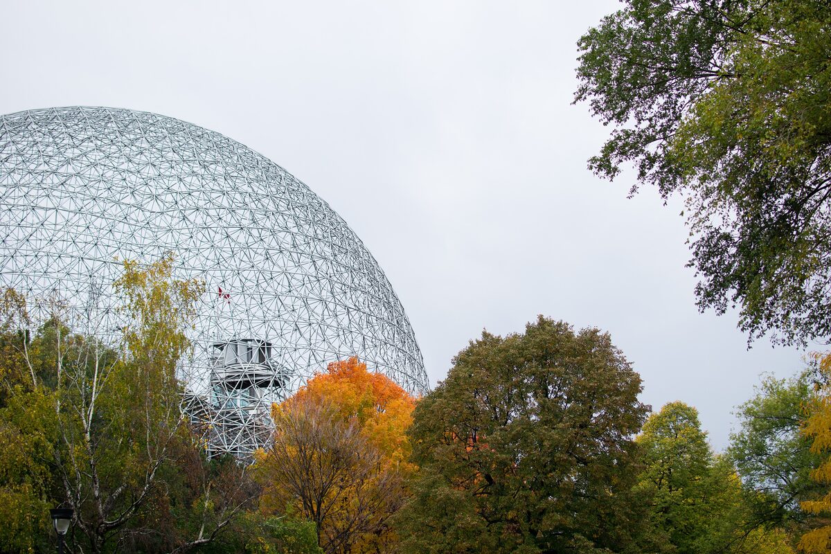 The Biosphère geodesic dome rising above orange and green autumn trees on Saint Helen's Island
