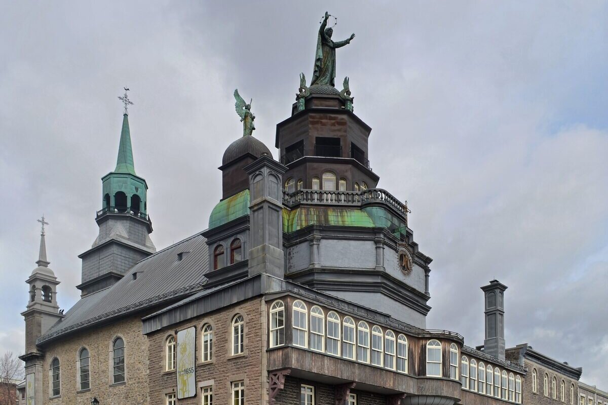 The stone Notre-Dame-de-Bon-Secours Chapel on the Old Port, with its green copper spires and a statue on the roof
