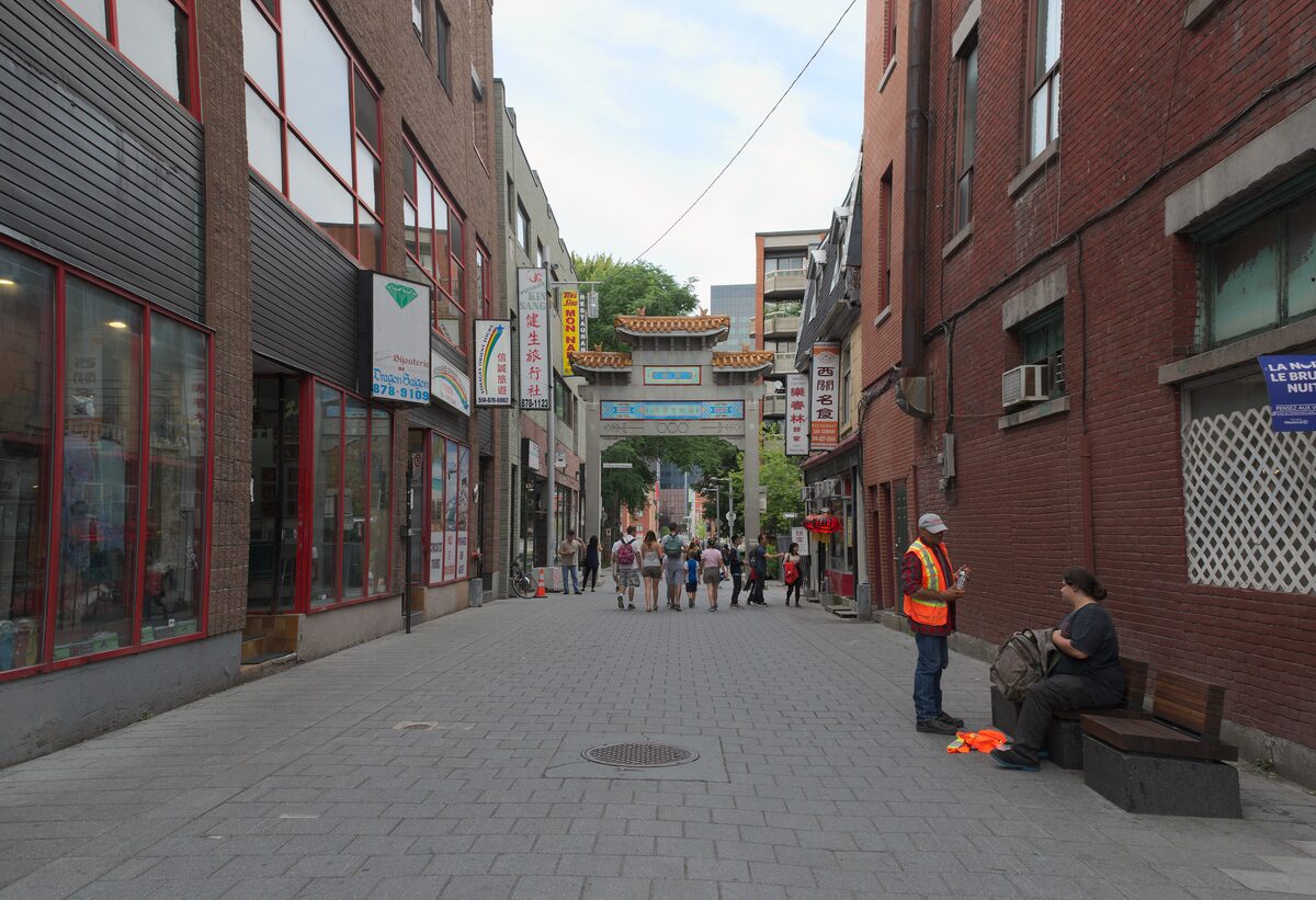 The pedestrian Rue de la Gauchetière in Chinatown, with the ornate Chinese gate at the far end of the brick-paved street