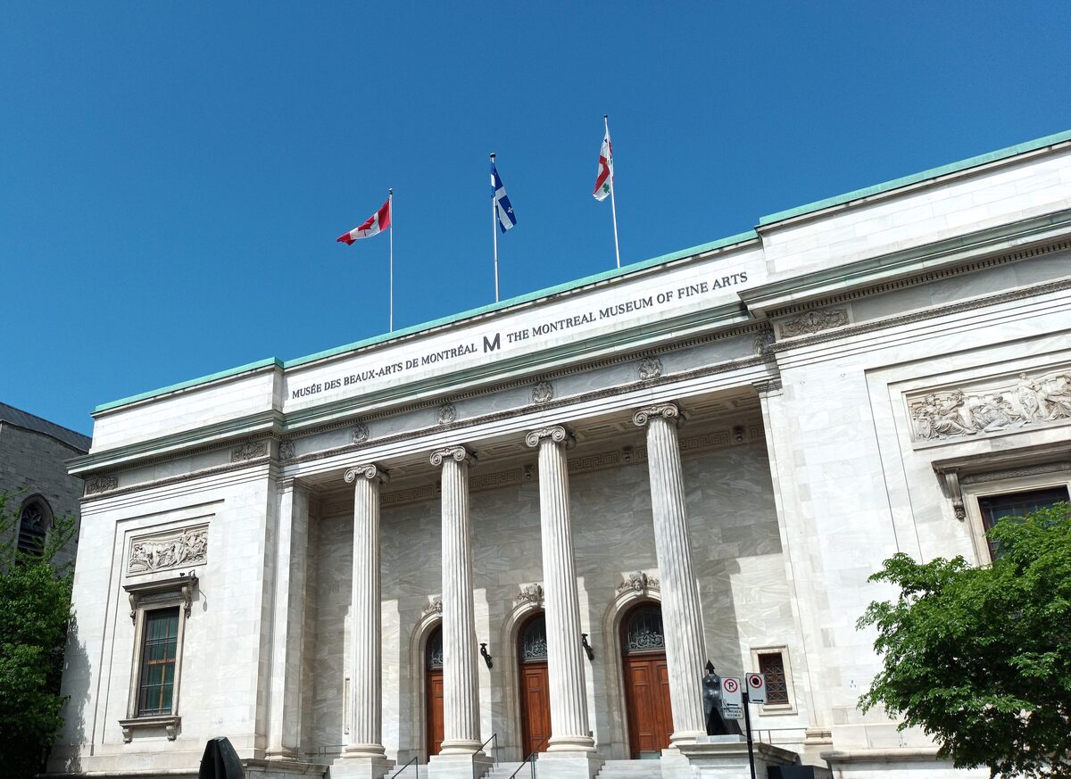 The white neoclassical facade of the Montreal Museum of Fine Arts, with its columns, entrance doors and the museum name on the frieze