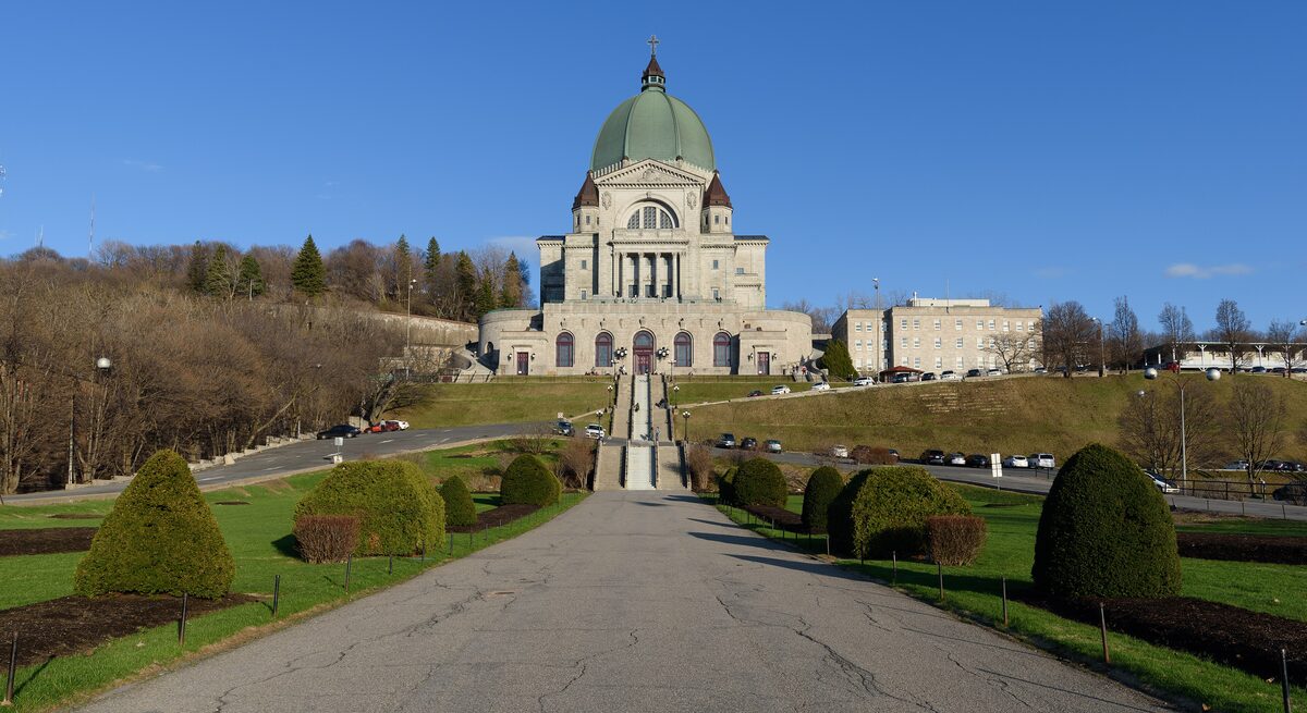 Saint Joseph's Oratory, a green-domed church at the top of a long path and stairs on the slope of Mount Royal, under a blue sky
