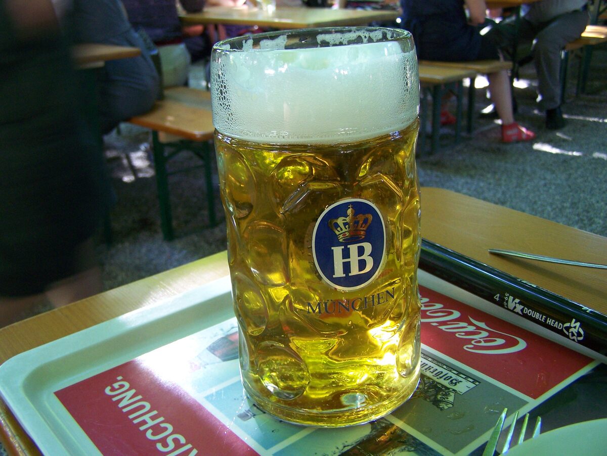 A one-liter Maß of Helles with a thick foam head in a Hofbräu glass