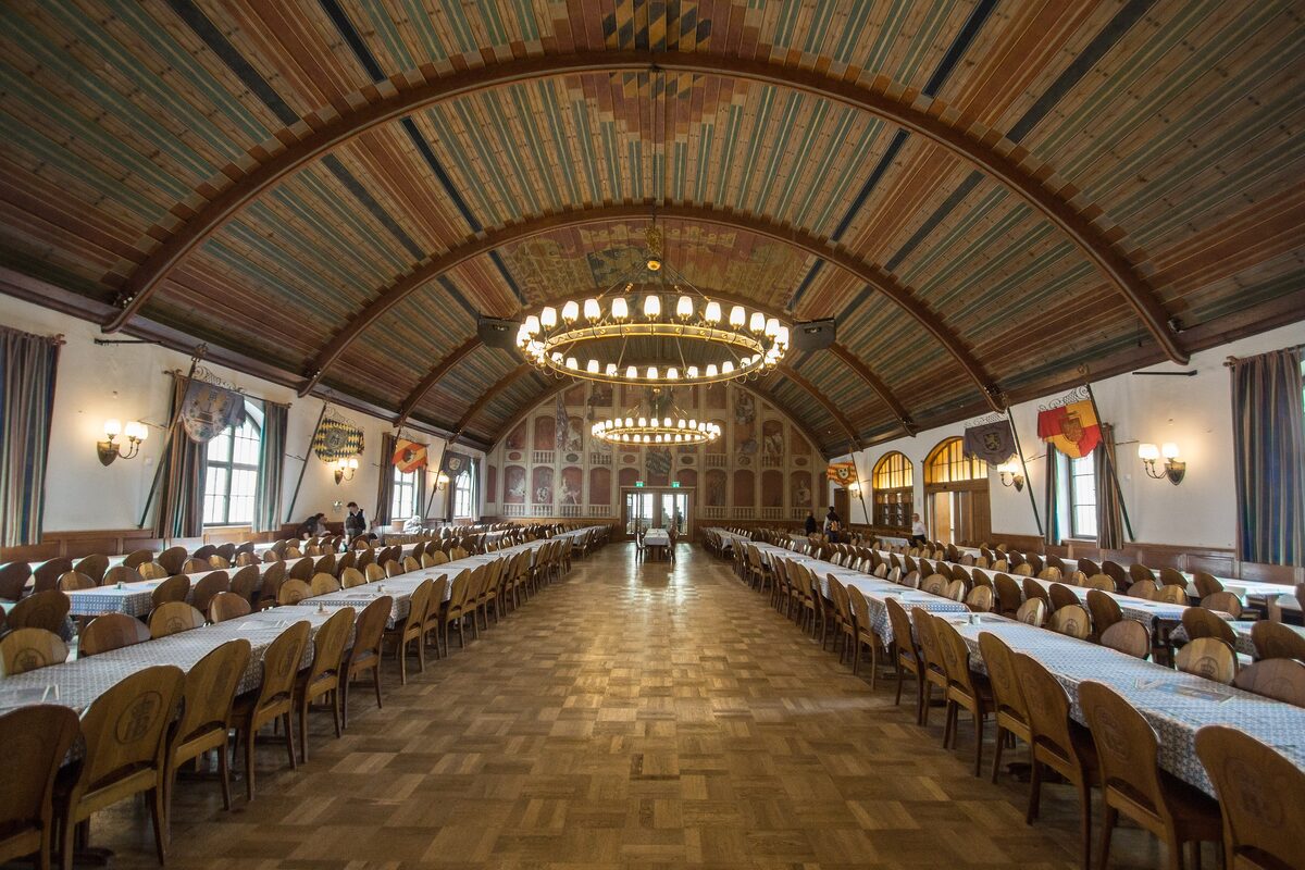 The painted, vaulted ceiling and long tables of the first-floor festival hall in the Hofbräuhaus