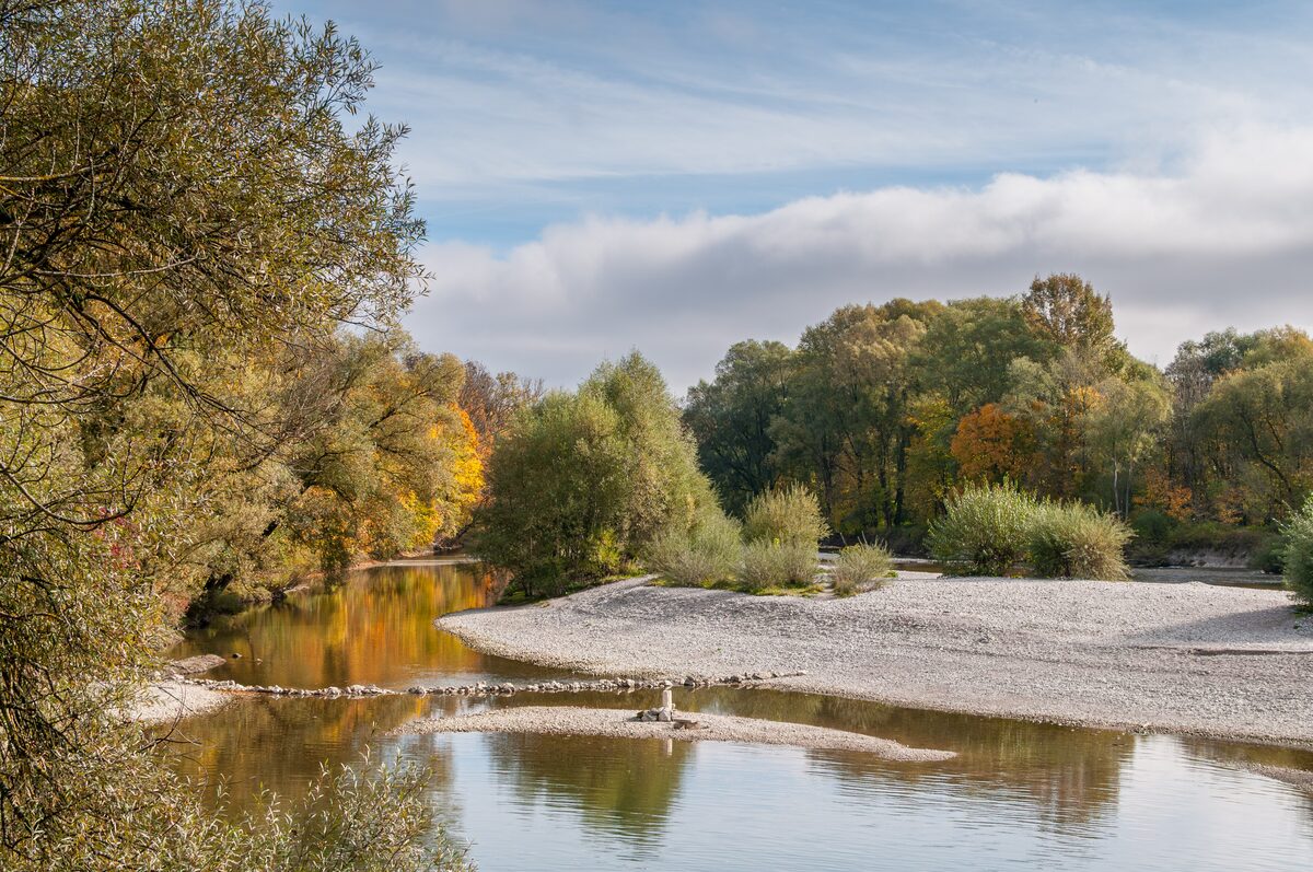 A gravel bank and autumn trees along the Isar at the Flaucher in the south of Munich