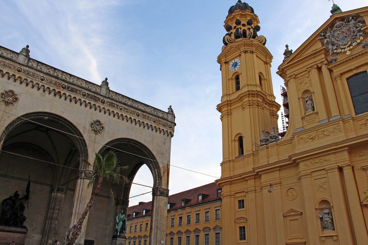 The arches of the Feldherrnhalle next to the yellow tower of the Theatinerkirche on Odeonsplatz
