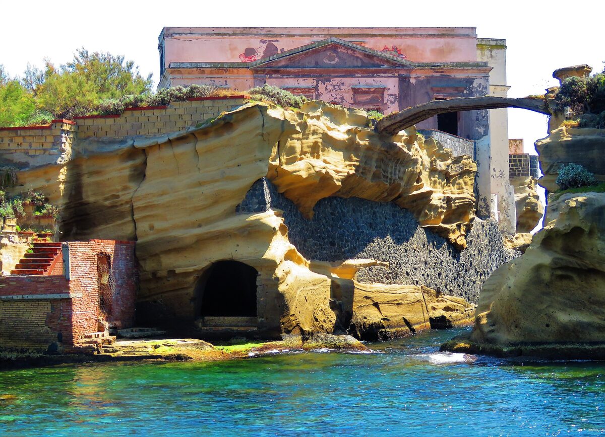 The tiny Gaiola island off Posillipo, with an old villa on top of golden tuff rocks and clear turquoise water below