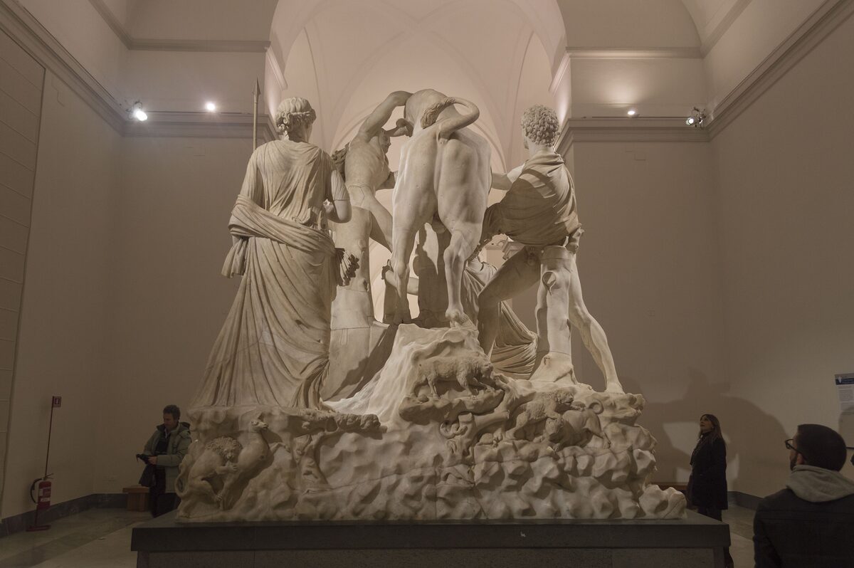 The marble Farnese Bull sculpture group, showing figures struggling with a rearing bull, in a high gallery of the Archaeological Museum of Naples