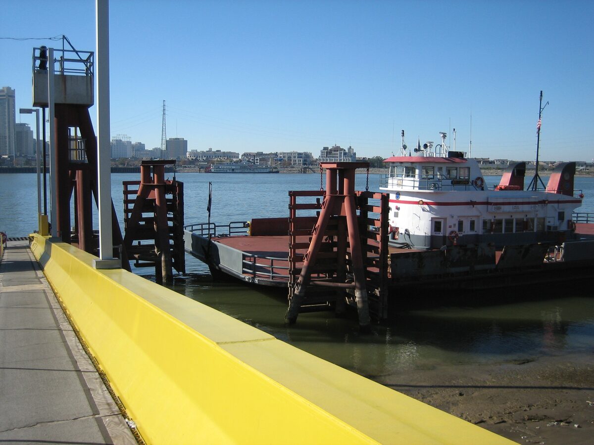 The Algiers ferry tied up at its landing on the Mississippi with the New Orleans skyline across the river