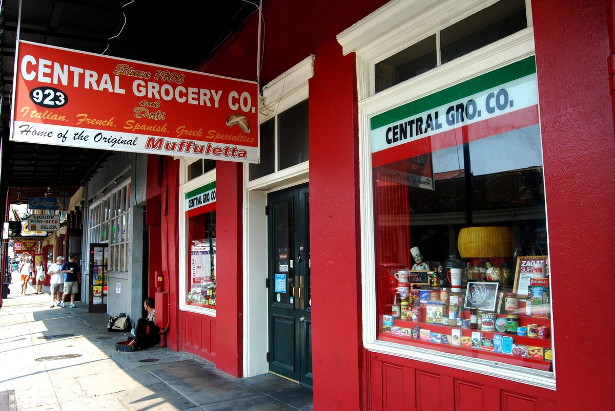 The red storefront of Central Grocery on Decatur Street with its sign reading Home of the Original Muffuletta
