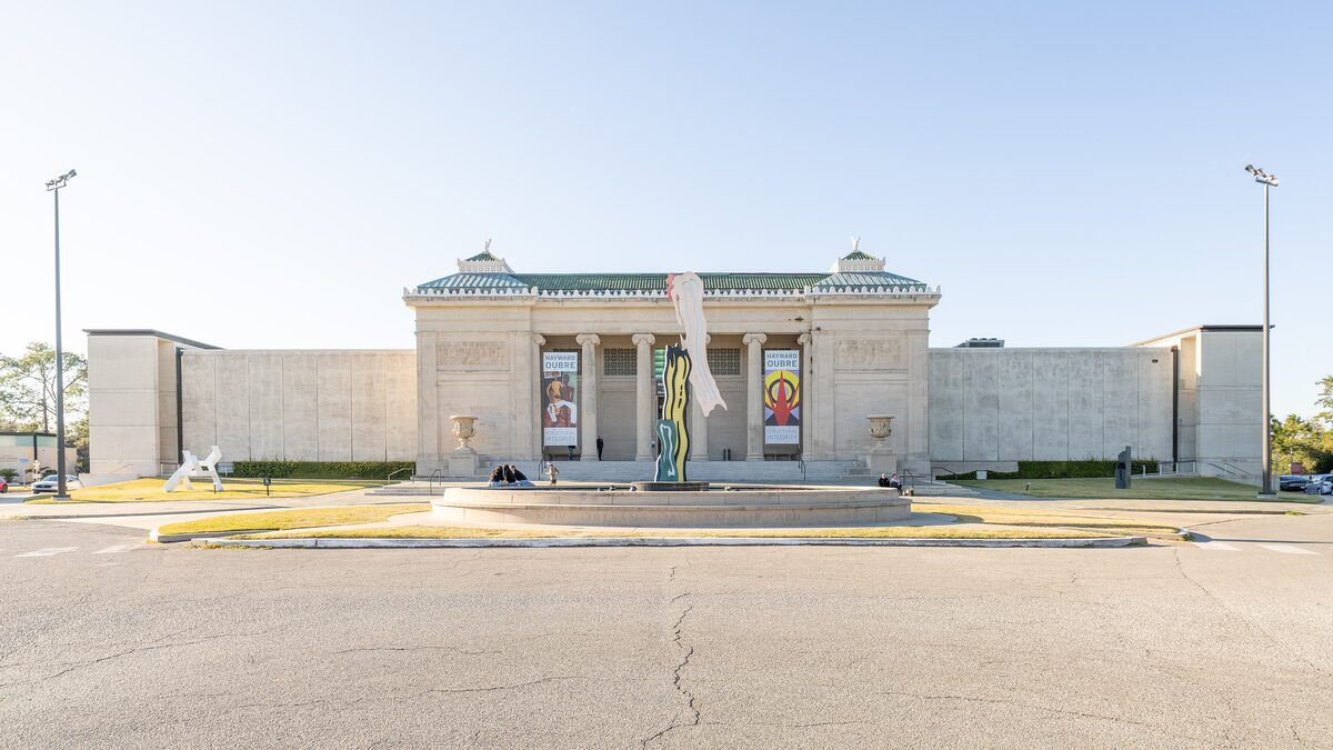 The columned neoclassical front of the New Orleans Museum of Art across its forecourt in City Park