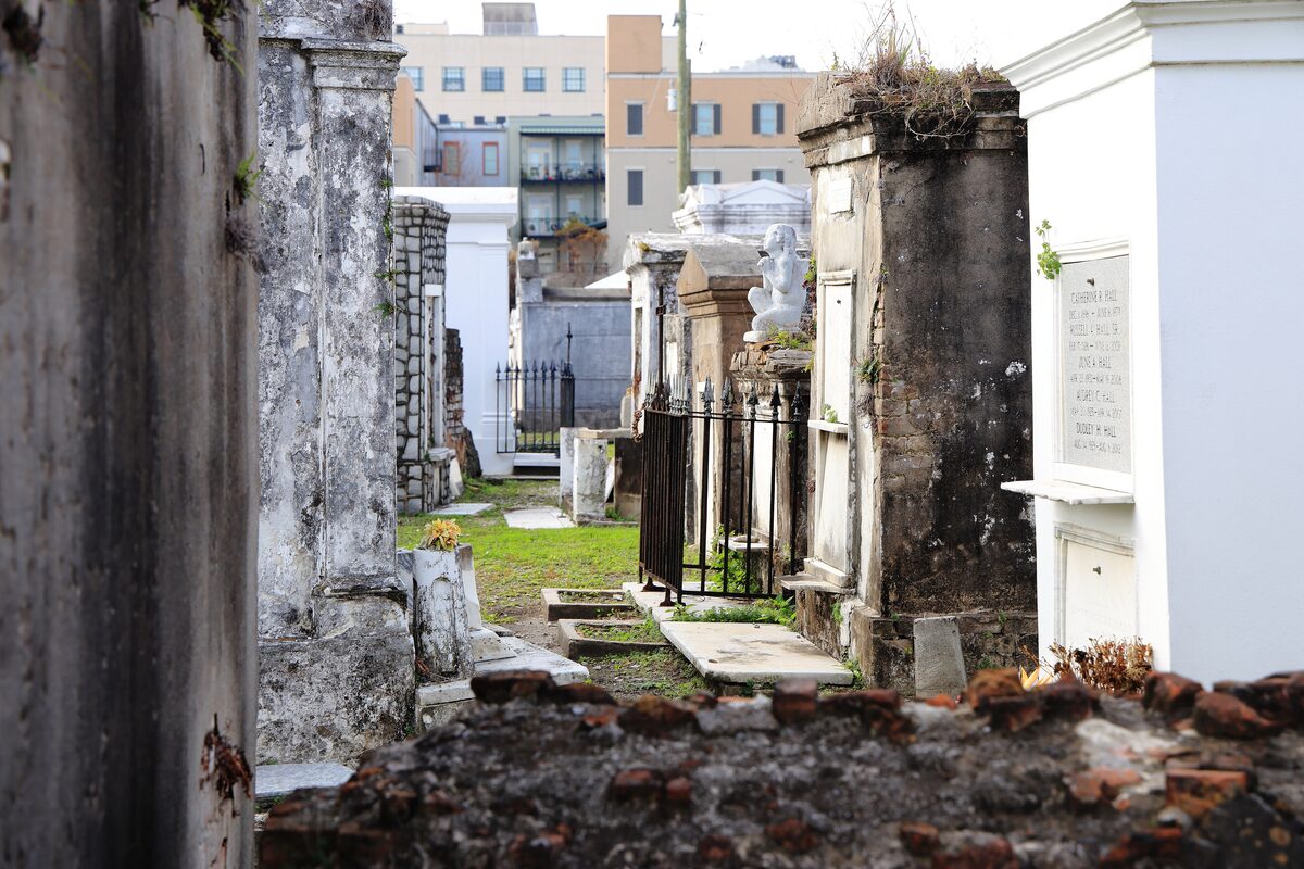 Weathered above-ground tombs in St. Louis Cemetery No. 1 with downtown buildings behind