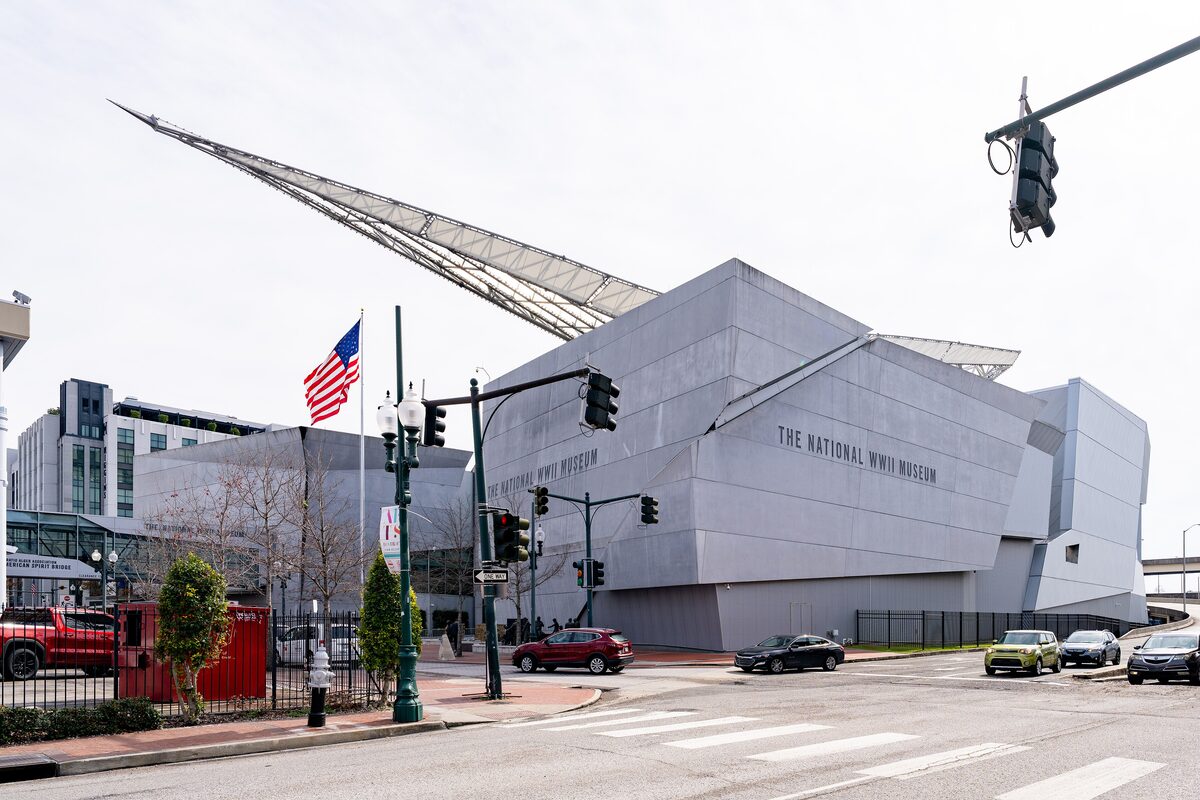 The angular grey Kushner Pavilion of the National WWII Museum with a long sloping steel fin and an American flag