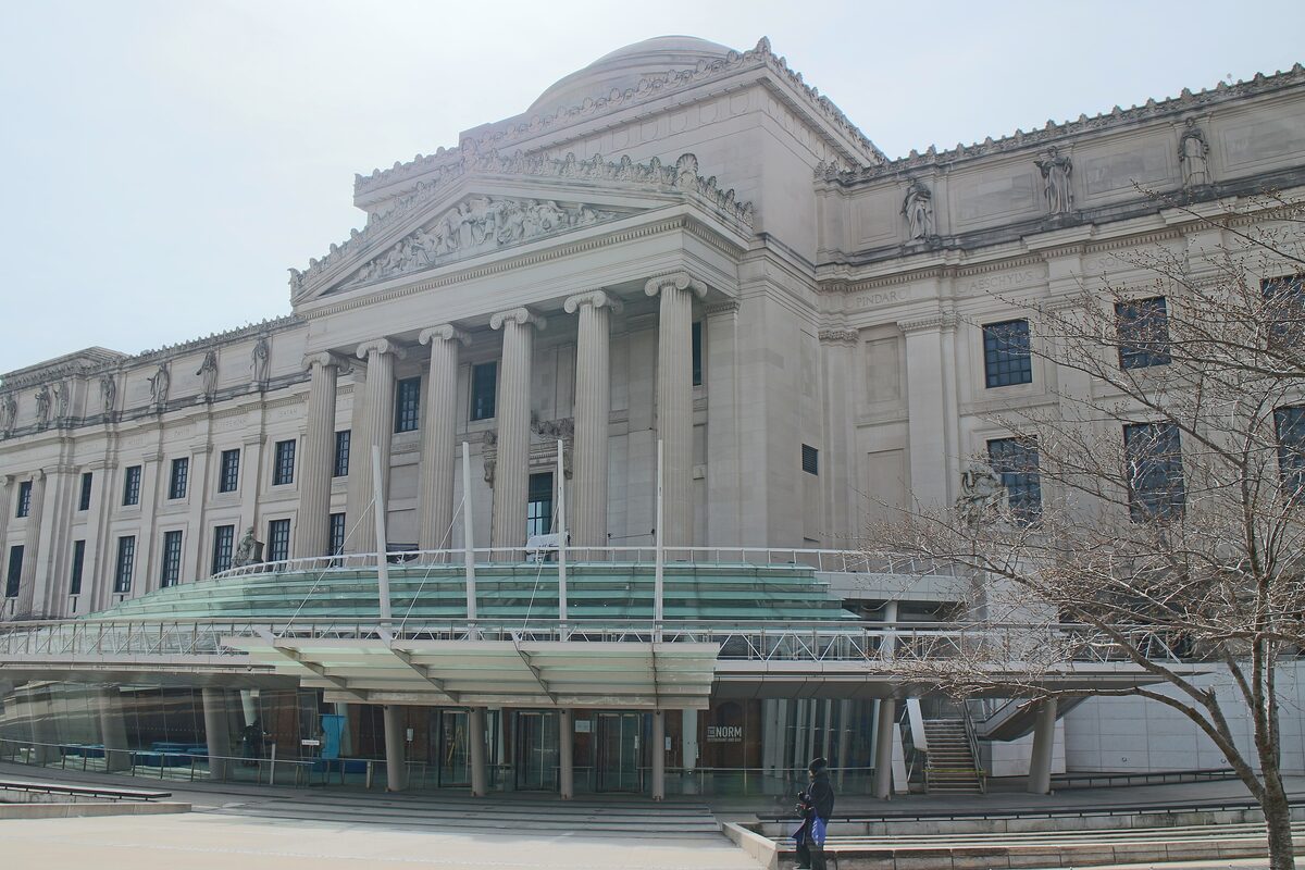 The columned Beaux-Arts facade of the Brooklyn Museum with its modern glass entrance pavilion at street level