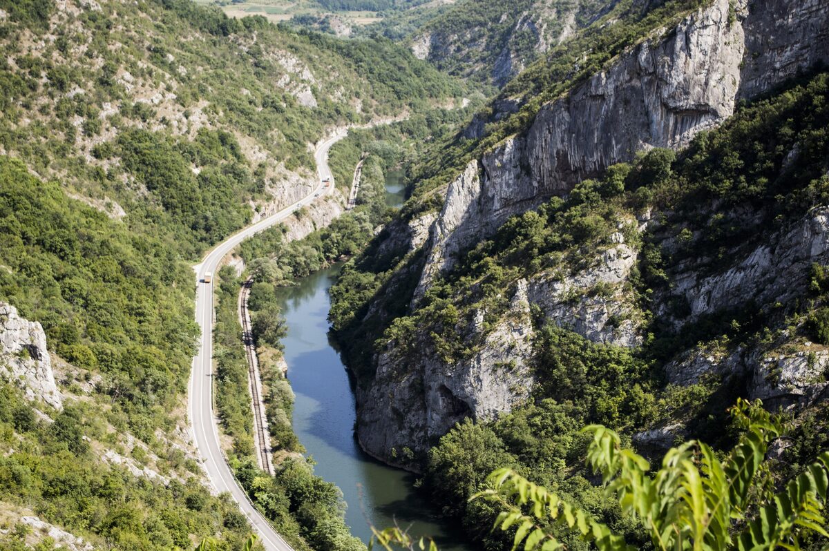 The Nišava winding through the Sićevo gorge below sheer limestone cliffs, with the road and railway squeezed along the left bank.