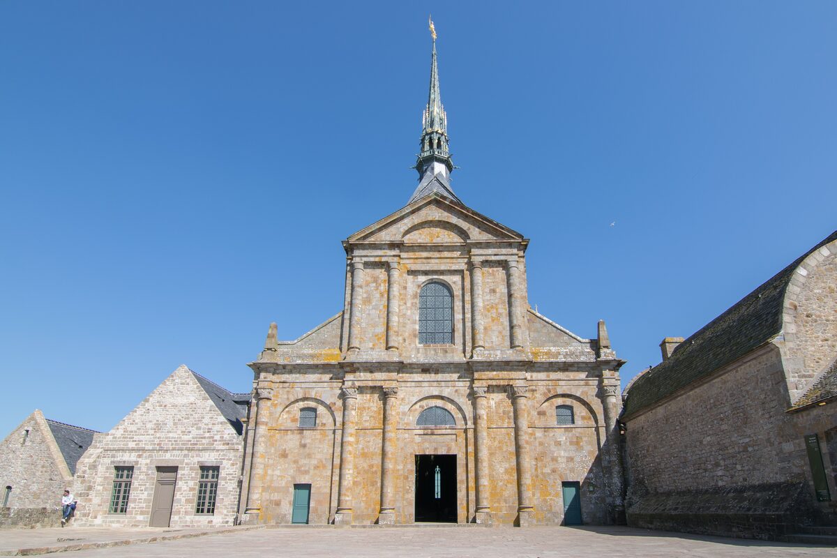 The west front of the abbey church of Mont-Saint-Michel on its terrace, under a blue sky
