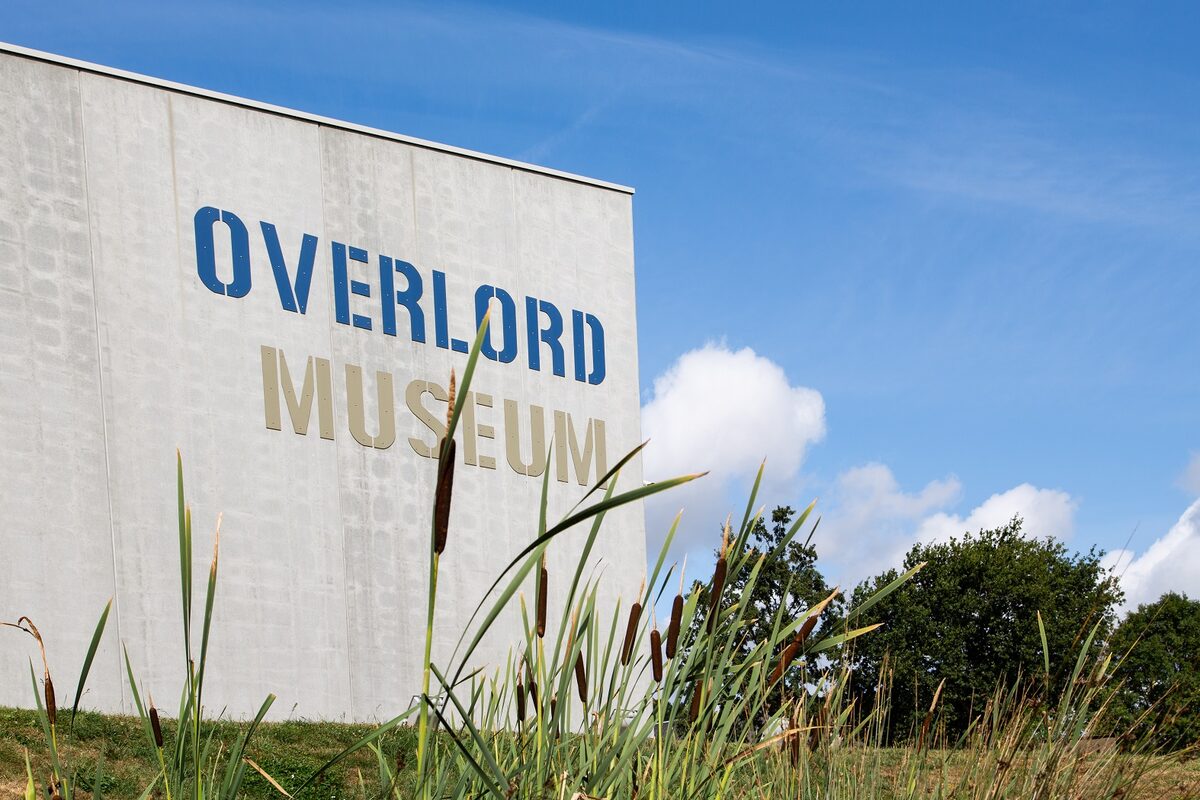 The concrete wall of the Overlord Museum at Colleville-sur-Mer with its name in blue and gold letters