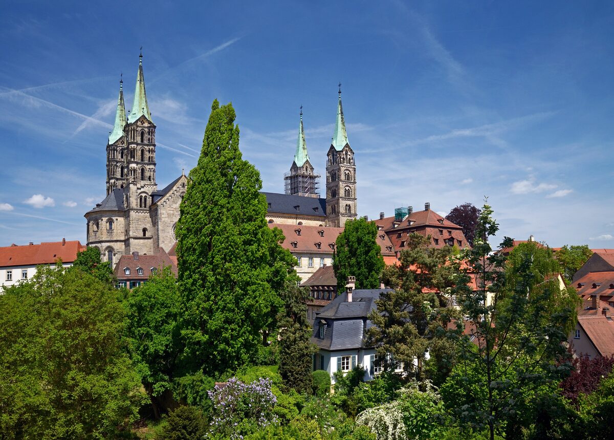 The four towers of Bamberg Cathedral rising above trees and rooftops on the Domberg