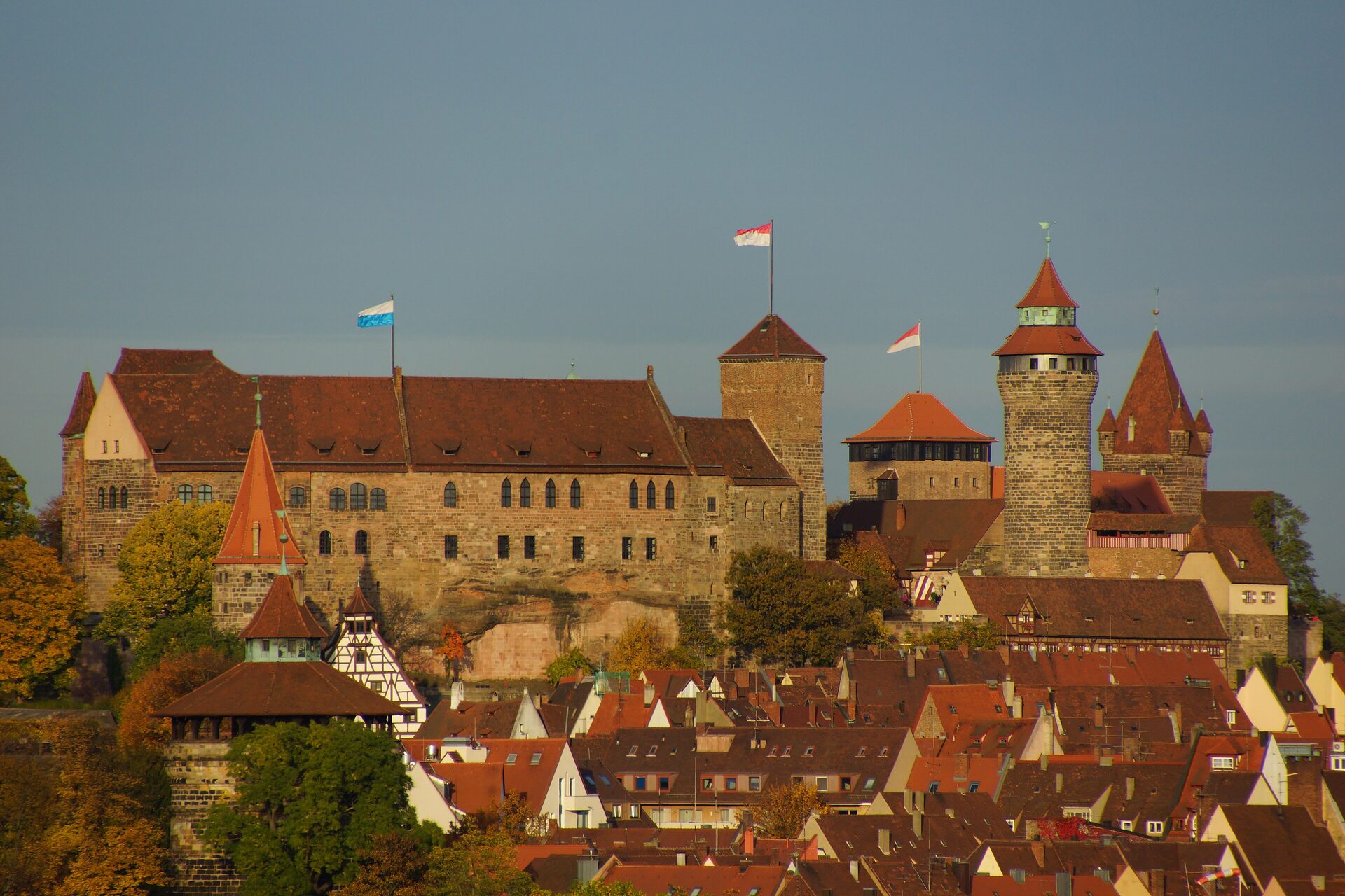 The Imperial Castle above the red roofs of Nuremberg's old town in autumn light, seen from the southwest