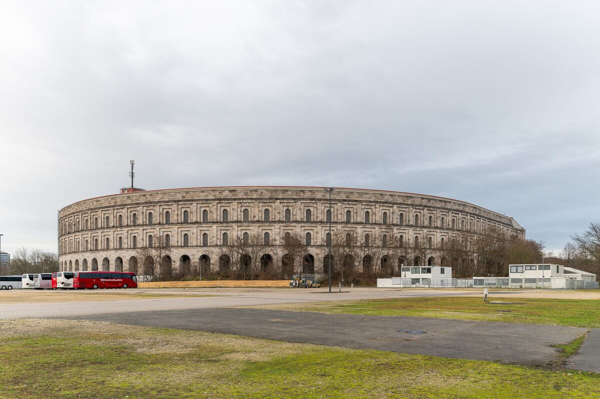 The curved granite shell of the unfinished Congress Hall seen across an open field