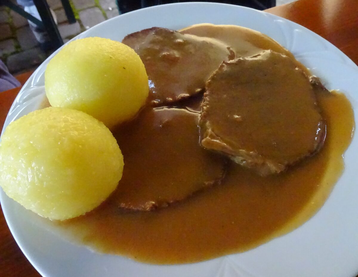 Slices of Franconian Sauerbraten with two potato dumplings in light gravy