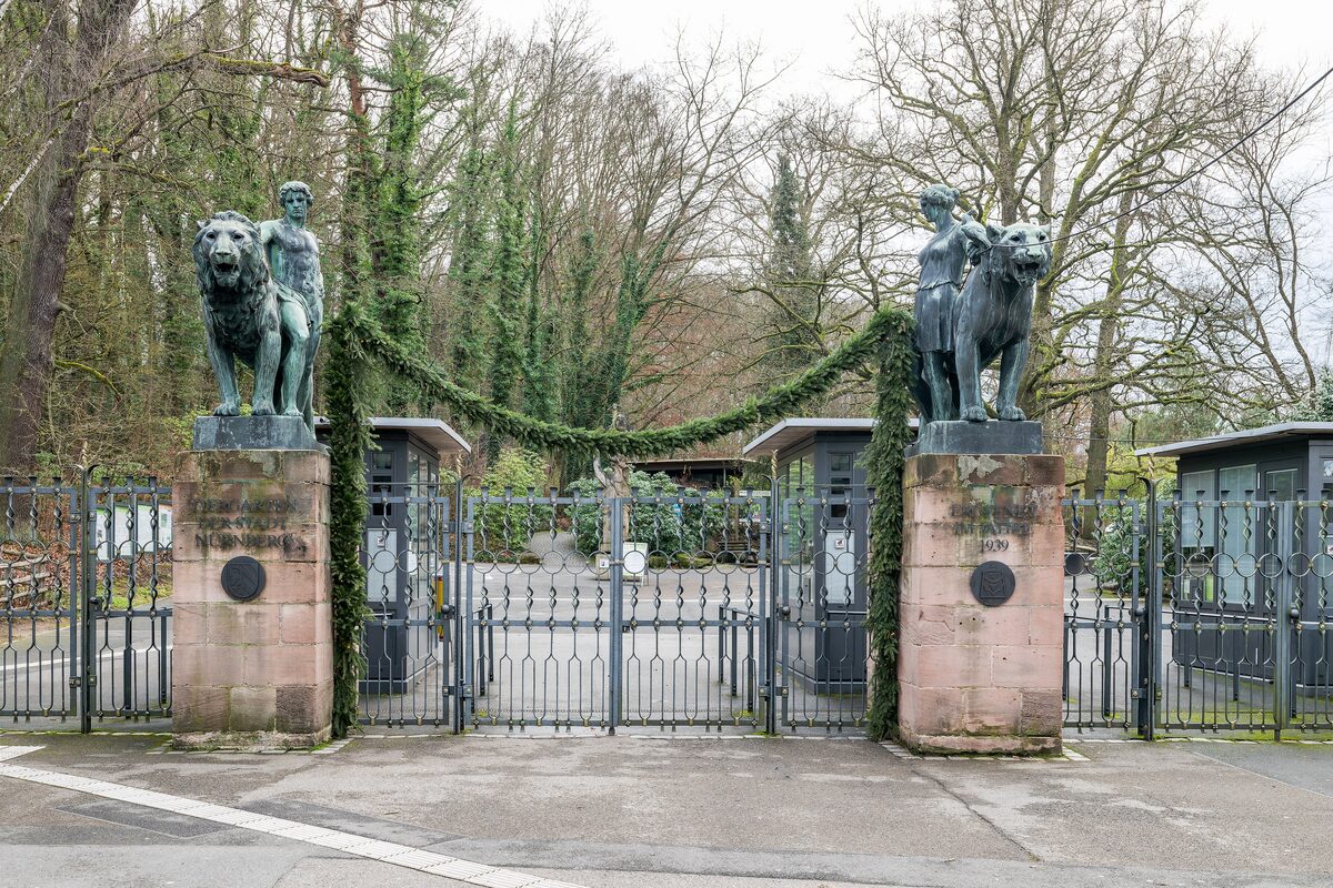 The entrance gate of the Tiergarten Nürnberg, with bronze lion and panther statues on stone pillars