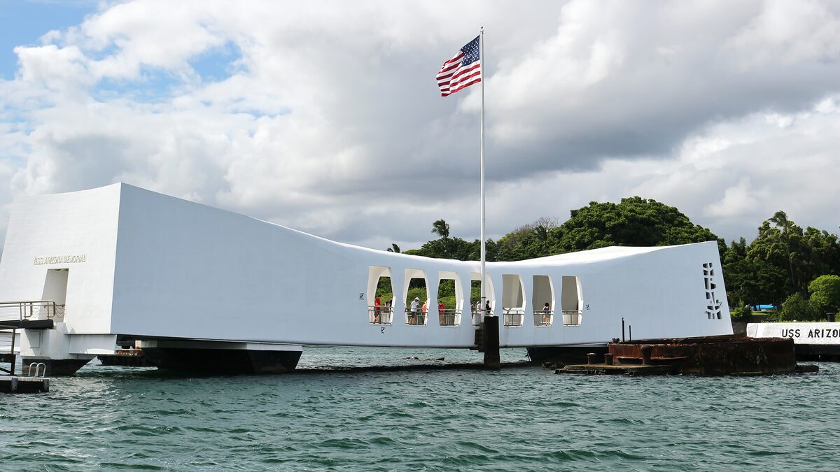 The white USS Arizona Memorial spanning the sunken battleship in Pearl Harbor
