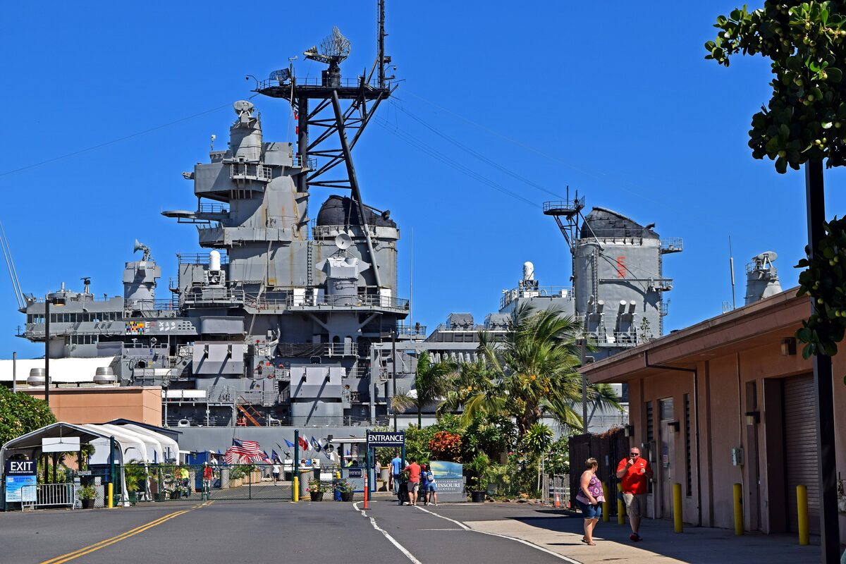 The battleship Missouri moored at Ford Island with visitors on the pier