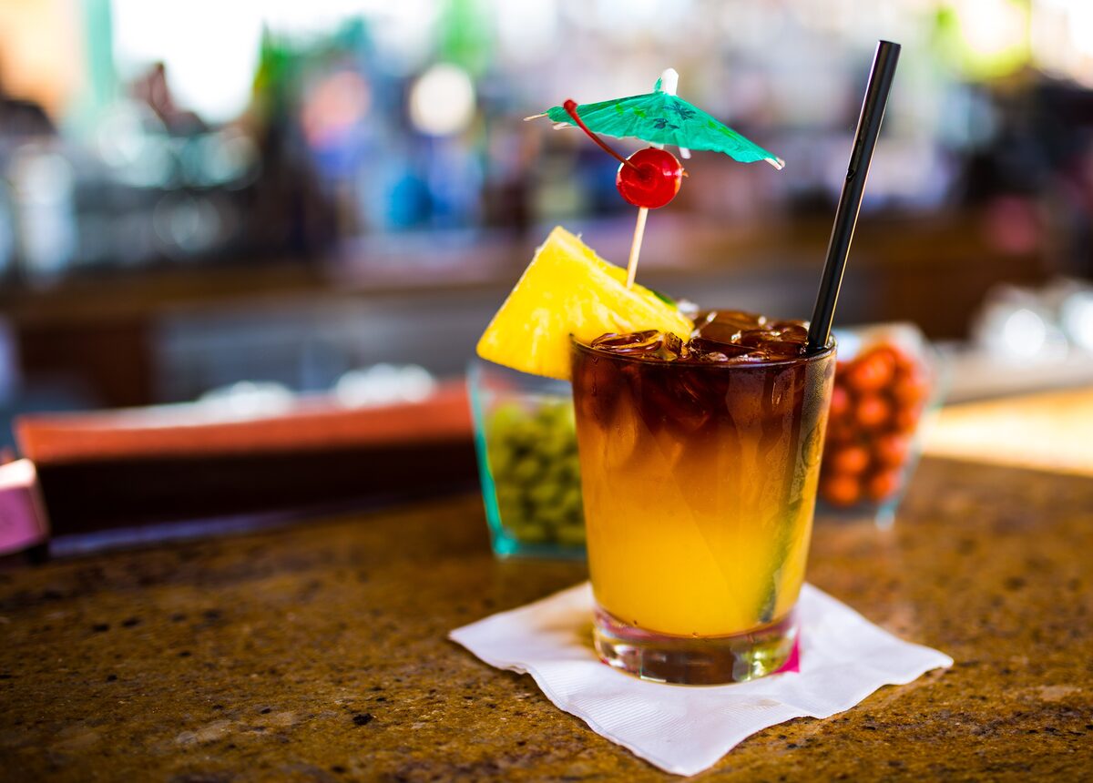 A mai tai with pineapple wedge and cherry on a bar counter