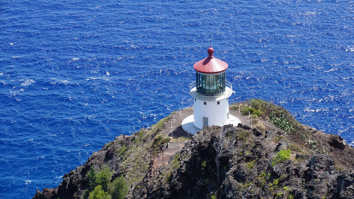 Makapuʻu Point lighthouse on its rocky headland above deep blue sea