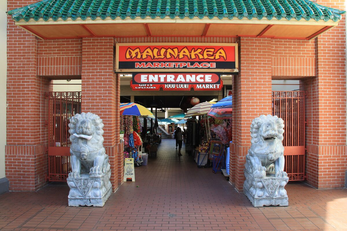 The green-tiled entrance of Maunakea Marketplace guarded by stone lions