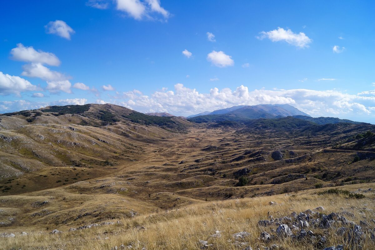 Brown grassy hills and rocky ridges of Galičica National Park under a blue sky