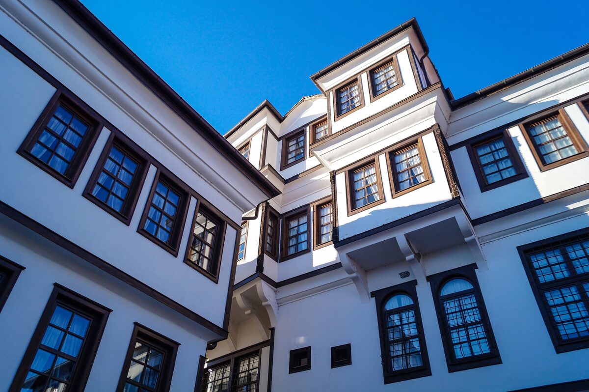 The white Robev family house with dark-framed windows and overhanging upper floors