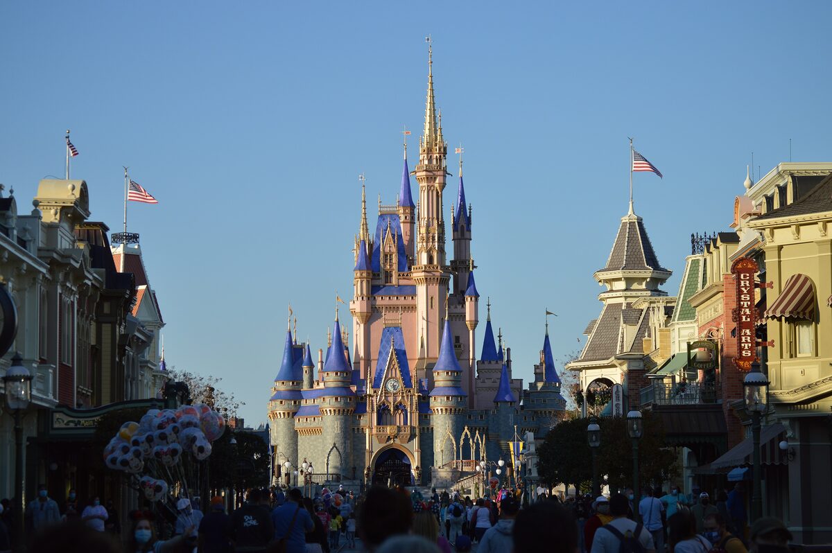 Cinderella Castle with its blue and pink spires at the end of Main Street, U.S.A., under a clear sky