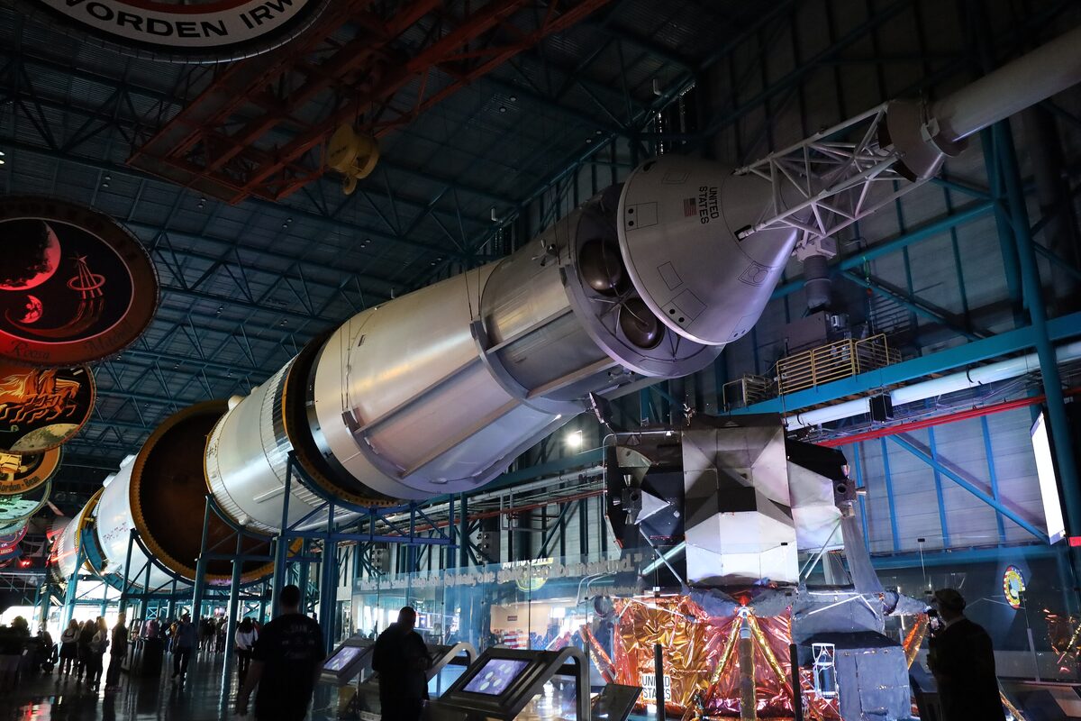 A Saturn V first stage lying on its side inside the Apollo/Saturn V Center, with the Apollo-era exhibits around it