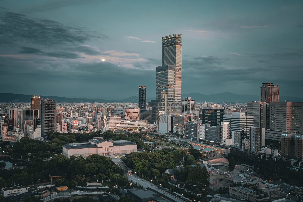 The Abeno Harukas tower rising above the Osaka skyline and Tennoji Park at dusk