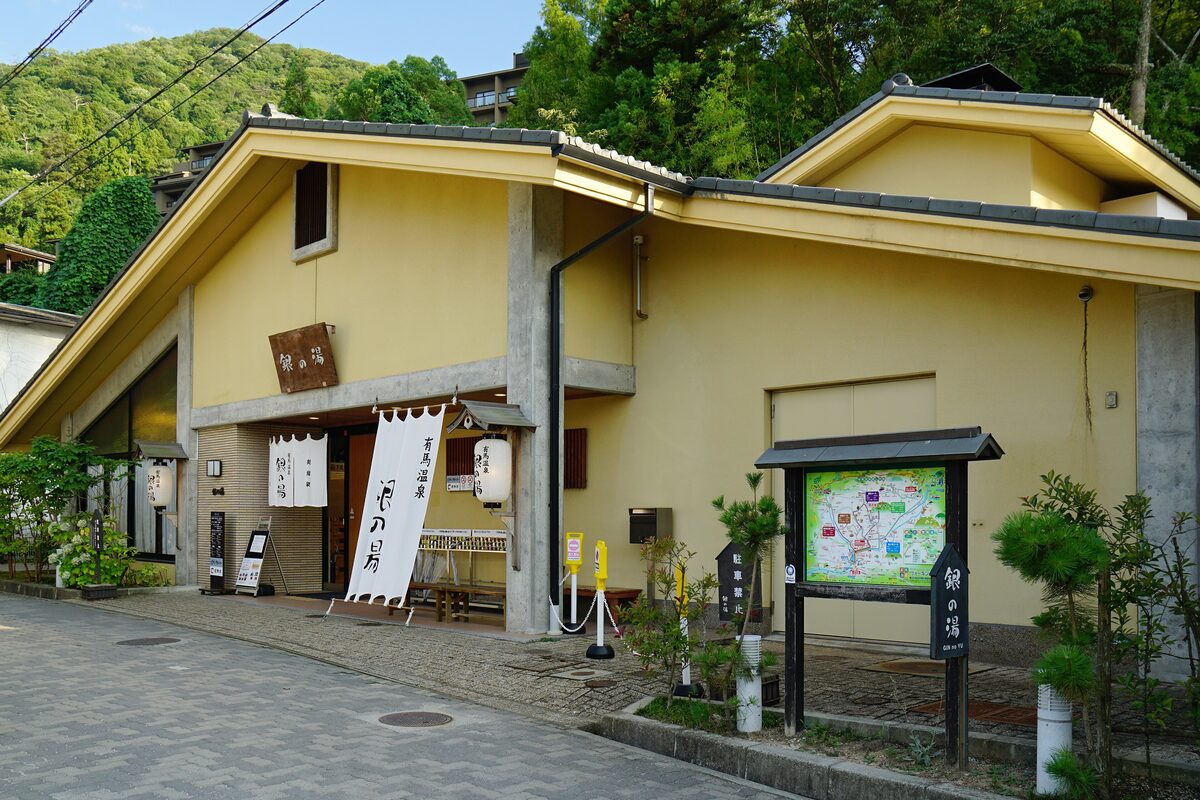Gin-no-yu, the yellow wooden bathhouse of Arima Onsen, with a map board at the entrance