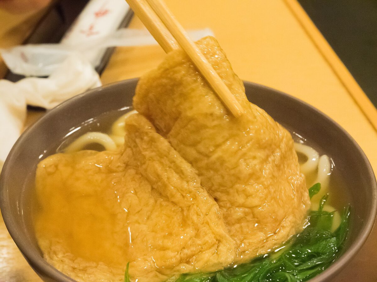 A bowl of kitsune udon with a sheet of sweet fried tofu on top