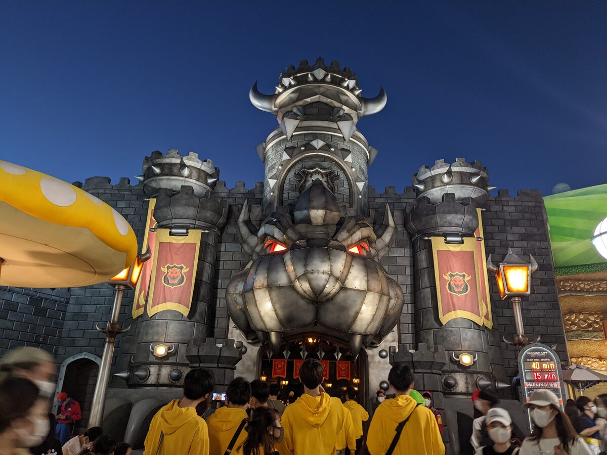 Bowser's castle at the Mario Kart ride in Super Nintendo World, with a crowd in front