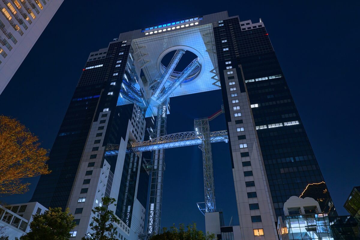 The Umeda Sky Building seen from below at night, its top lit in blue