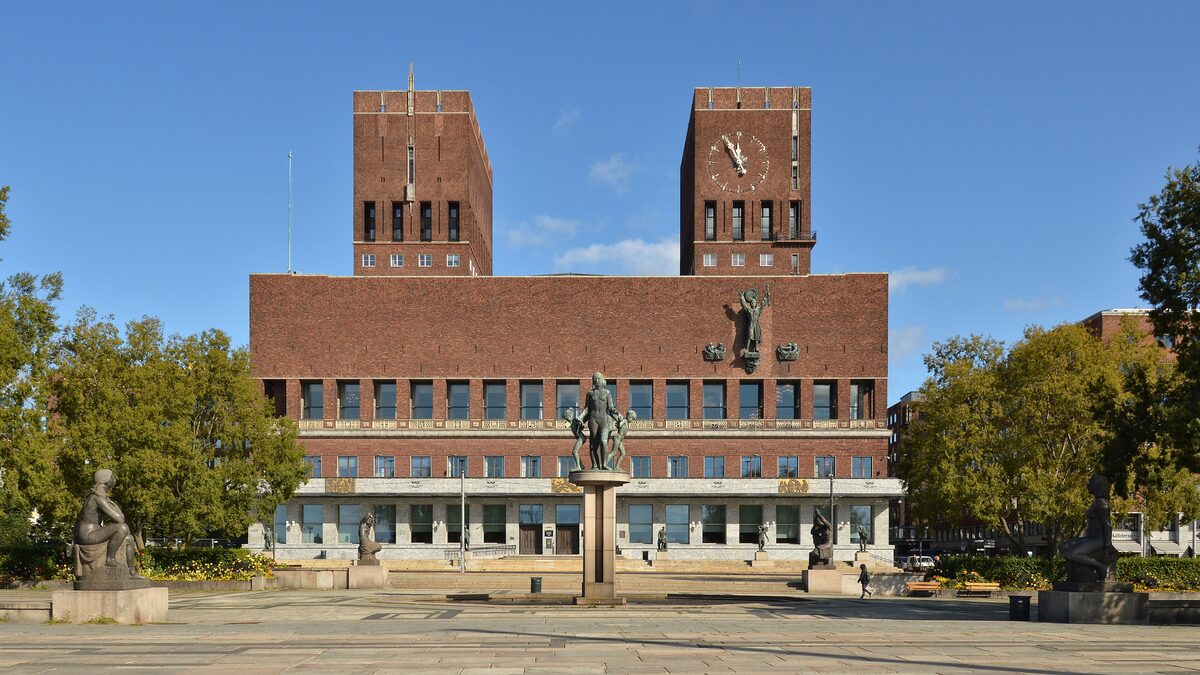 Oslo City Hall, a red-brick building with two square towers, behind a paved square with statues