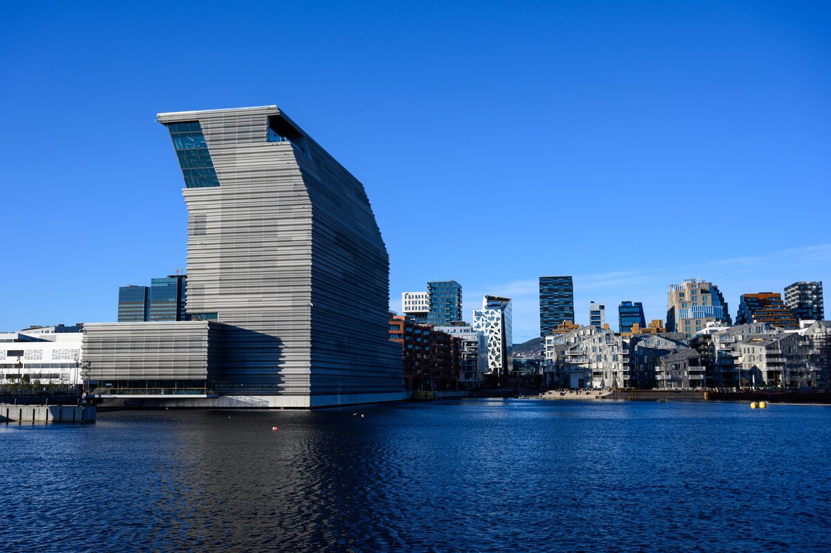 The tall, leaning grey tower of the MUNCH museum on the Bjørvika waterfront, with the Barcode high-rises behind