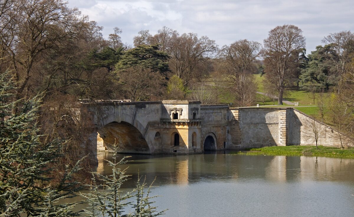 The lake and Vanbrugh's Grand Bridge in the parkland of Blenheim Palace, with trees on the far bank