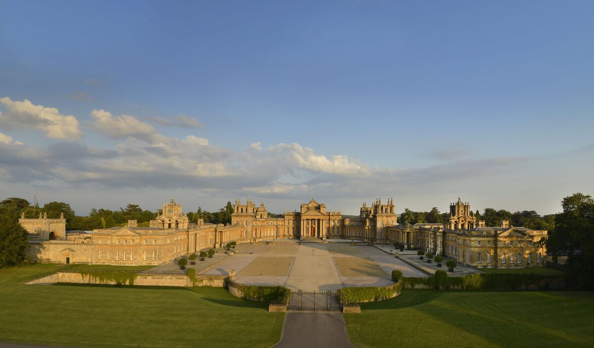 Blenheim Palace, a vast baroque palace with towers and a columned portico, seen across a great courtyard