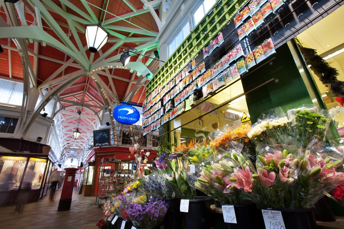 The covered market in Oxford, a long arcade of small shops and cafés under a wooden roof