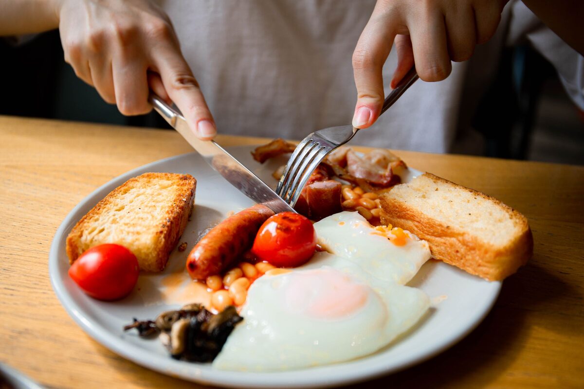 A full English breakfast with fried eggs, bacon, sausages, beans, mushrooms, tomato and toast